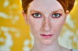 red head, green eyes and yellow wall