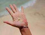 a white wet sand in sunburned hand
