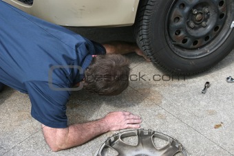 Mechanic Looks Under Car