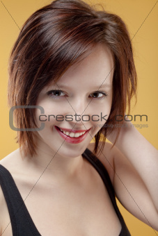 portrait of a beautiful teenage girl smiling - isolated on yellow