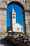 White Church Framed in the Arch of Ancient Roman Amphitheater 
