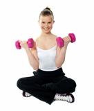 Smiling young girl lifting weights