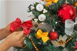 Closeup on woman hand decorating Christmas tree
