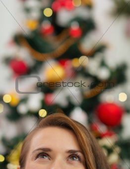 Closeup on female head in front of Christmas tree looking up