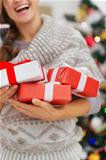 Closeup on Christmas present boxes holding by happy woman