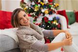 Happy Woman sitting near Christmas tree