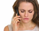 Portrait of concerned woman talking mobile phone