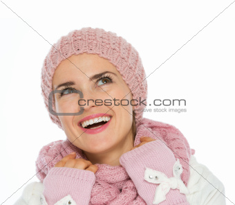 Smiling woman in knit winter clothing looking up on copy space