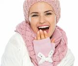 Portrait of smiling woman in knit scarf, hat and mittens