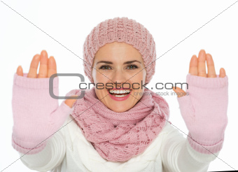 Happy young woman in knit winter clothes framing with hands