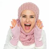 Happy woman in knit winter clothes shouting through megaphone shaped hands