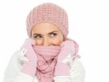 Happy woman in knit winter clothes hiding in scarf and looking on copy space