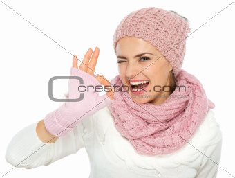 Smiling woman in knit winter clothes showing ok gesture