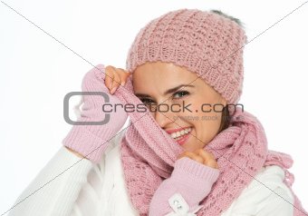 Happy young woman hiding behind knit scarf