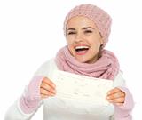 Happy young woman in knit winter clothing holding air ticket