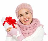 Happy young woman in knit winter clothing holding Christmas present box