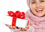 Closeup on Christmas gift box in hand of woman in winter clothing