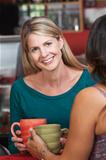 Smiling Blond Woman with Friend in Bistro