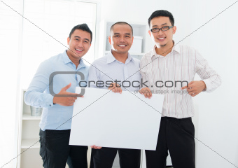 Asian business team holding a blank banner