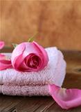 Spa concept with rose petals on a wooden background