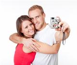 happy young couple taking pictures of themselves - isolated on white