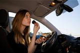 Young pretty woman preparing her make-up in car