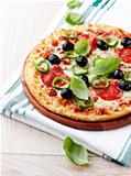 Pizza with salami, chili pepper and olives