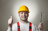 Smiling young worker with a wrench
