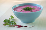 Chlodnik - cold beetroot soup in a bowl on a wooden table.