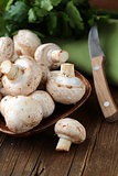 Fresh champignon mushrooms on a wooden table