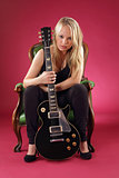 Beautiful blond sitting with electric guitar
