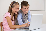 Two young students working on a laptop