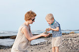 cute kid at the beach with his mother