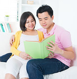 Asian couple reading book together