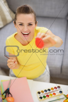 Smiling young woman showing Easter red egg