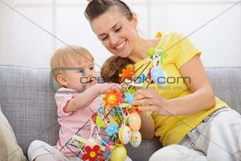 Happy mother and baby making Easter decoration
