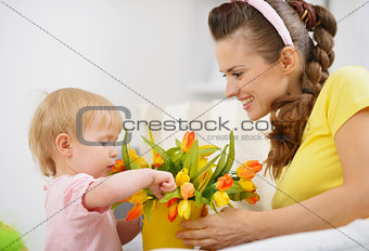 Happy mother and baby making decoration with bouquet of tulips i