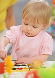 Baby painting on Easter eggs