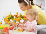 Mother and baby making Easter decorations