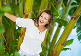 Happy young woman among tropical palms