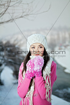Girl in bright clouthes on snow winter background