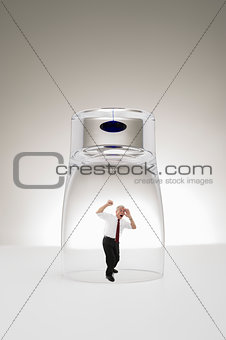 Senior businessman trapped under a glass
