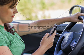 Woman driver reading a text message