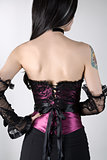 Rear view of a woman in purple corset with lace overlay 