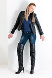 standing woman wearing jeans and black boots