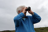 A senior lady using binoculars
