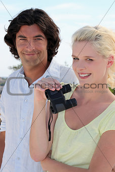 Couple using binoculars on a sunny day