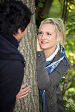 a blonde woman watching lovingly a man in the forest