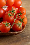 Fresh cherry tomatoes on wooden plate