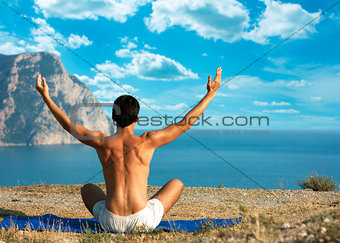Man Doing Yoga at the Sea and Mountains